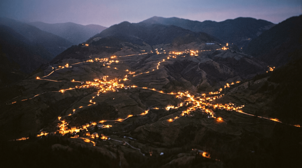 Mountain village with winding illuminated roads at night